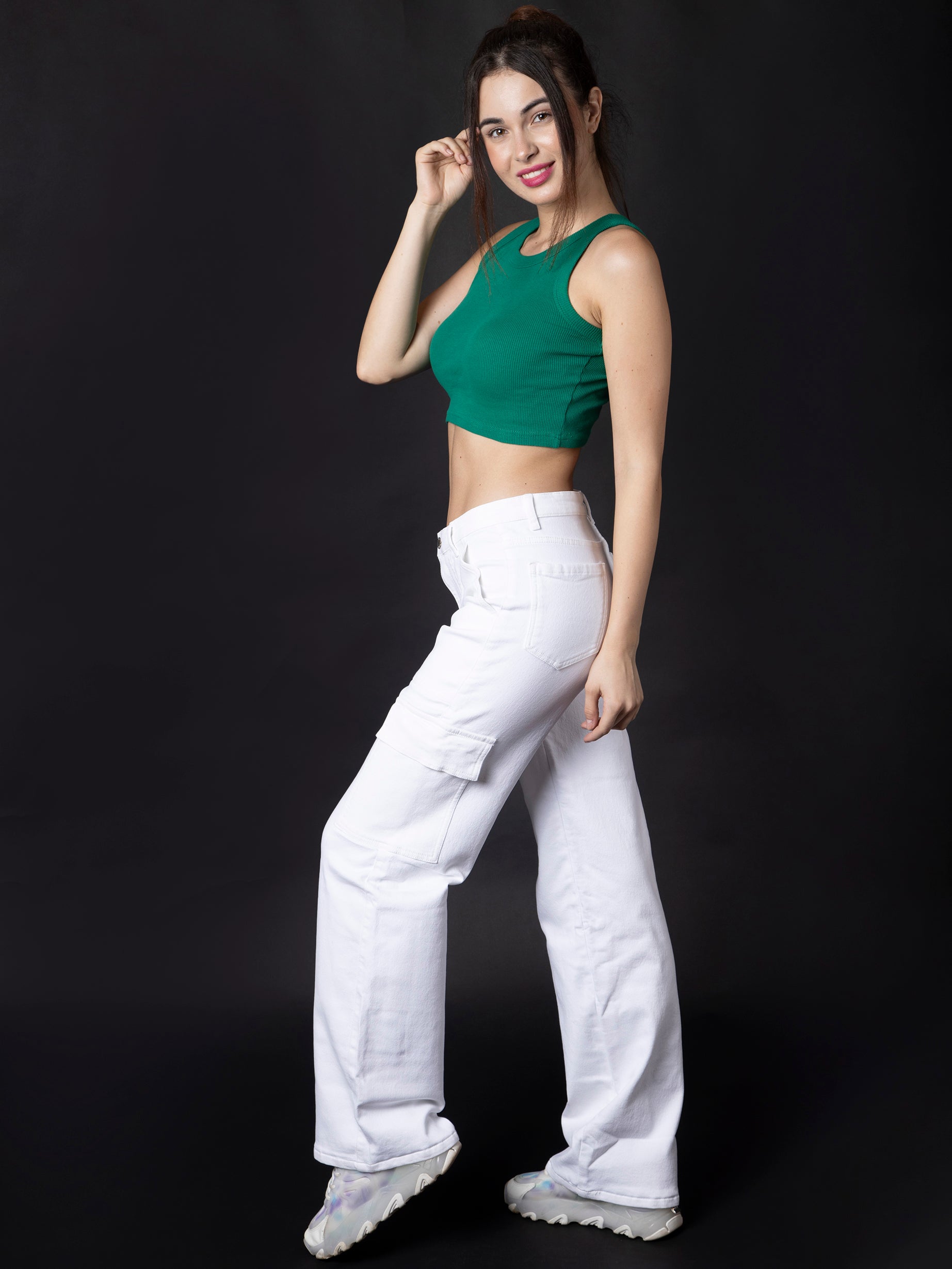  Stylish white cargo denim jeans from OMG Jeans, featuring a high-waist fit with utility pockets, paired with a green crop top and trendy sneakers for a bold and modern look.